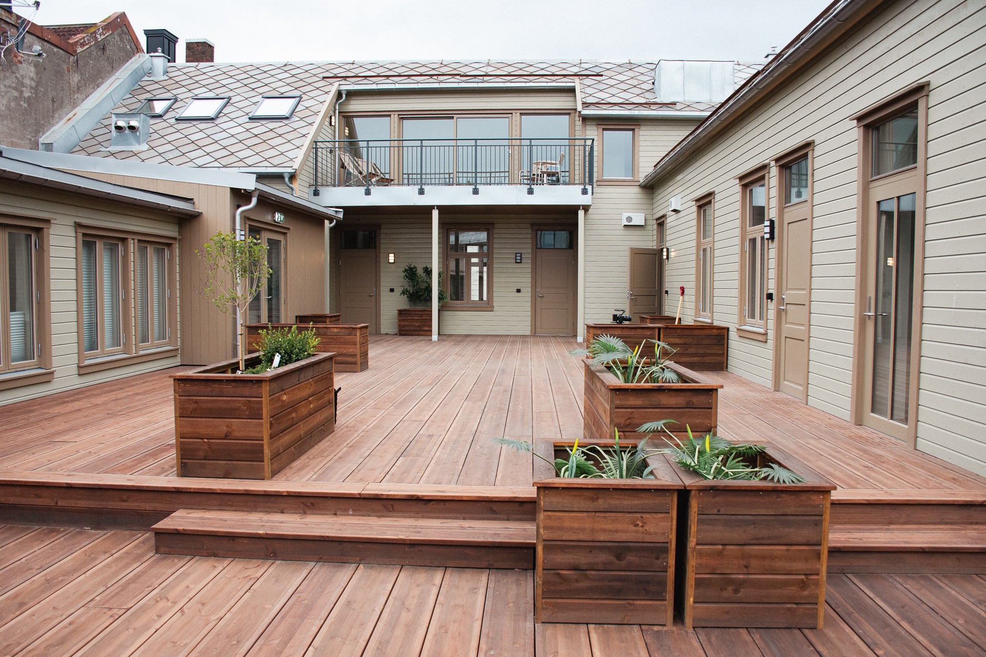 Opparbeidet terrasse med plantekasser i bakgården i Kirkegata 43